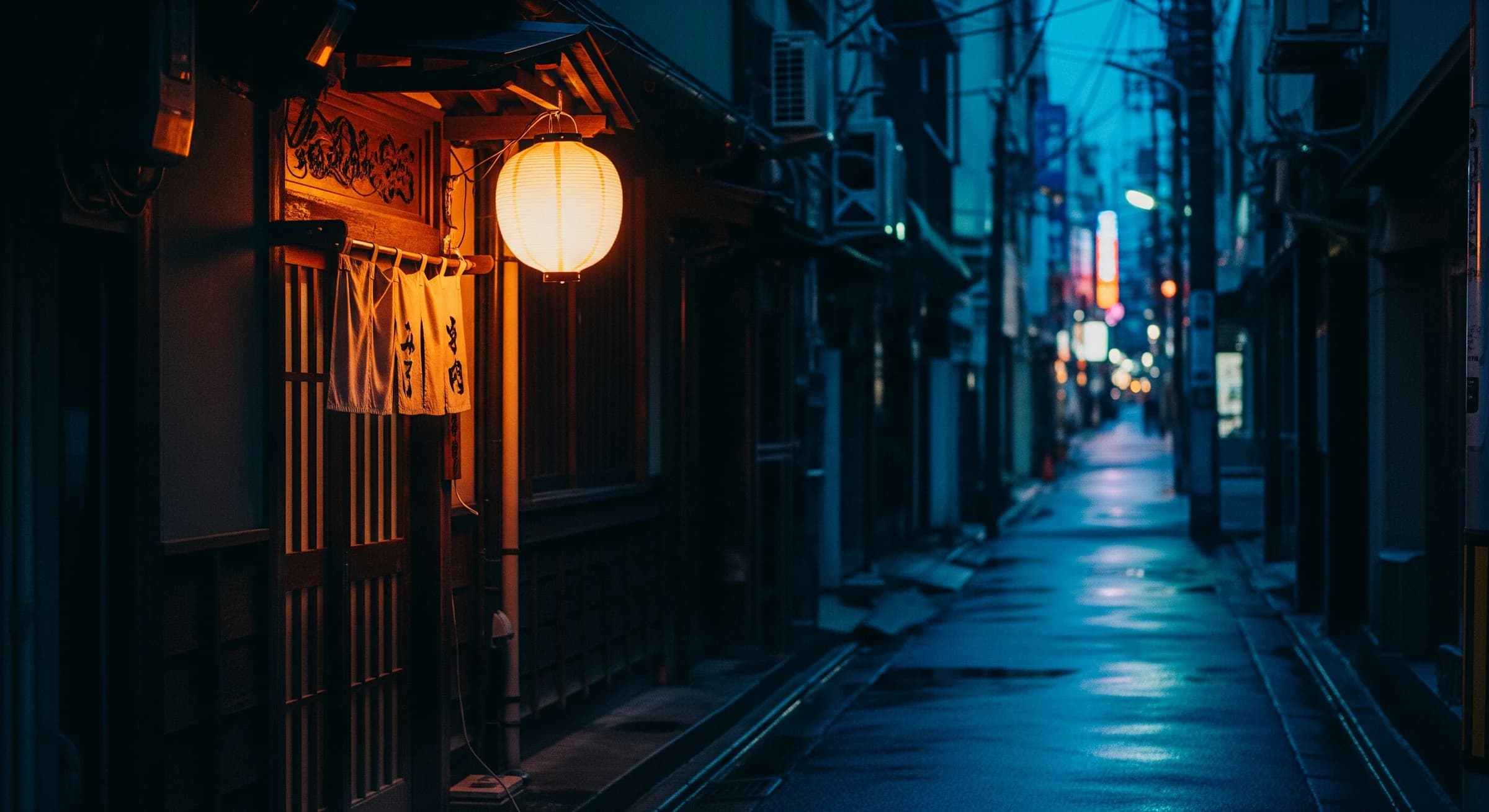 夕暮れの路地に灯る提灯と居酒屋の入り口